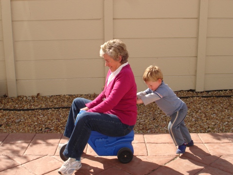 Child_pushing_grandmother_on_plastic_tricycle.jpg